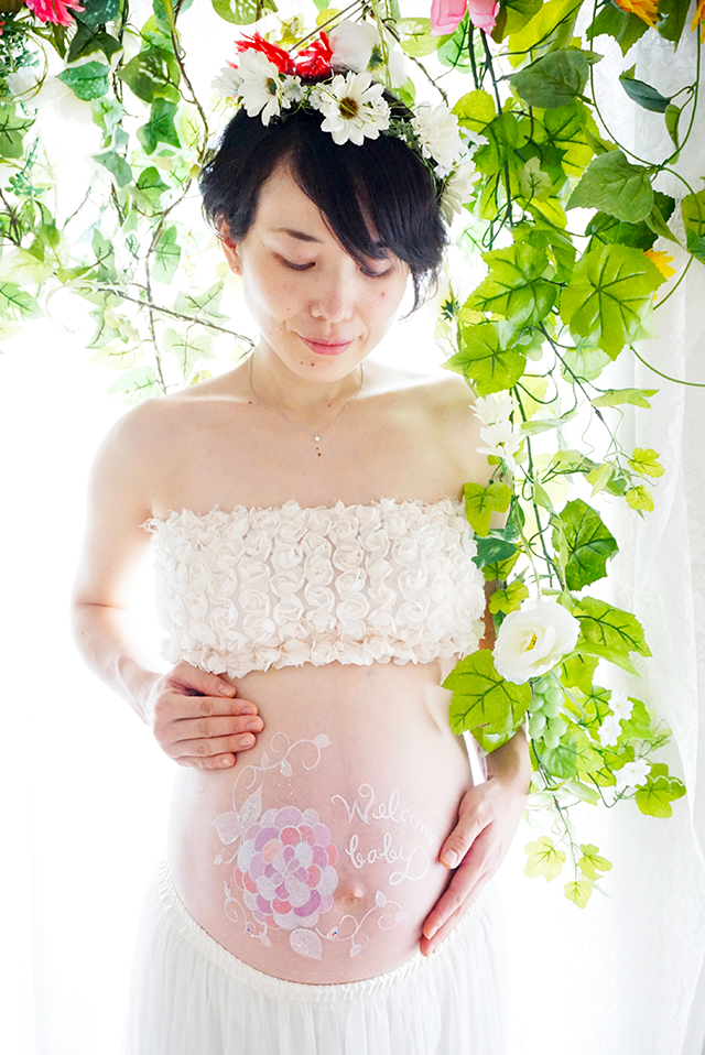 白とピンクをベースに淡い色合いで描かれた紫陽花のベリーペイント。白が貴重になっているため、とても可愛くておしゃれに仕上がっているマタニティペイントです。妊婦さん全体を撮影することで構図がよくわかる一枚になっています。