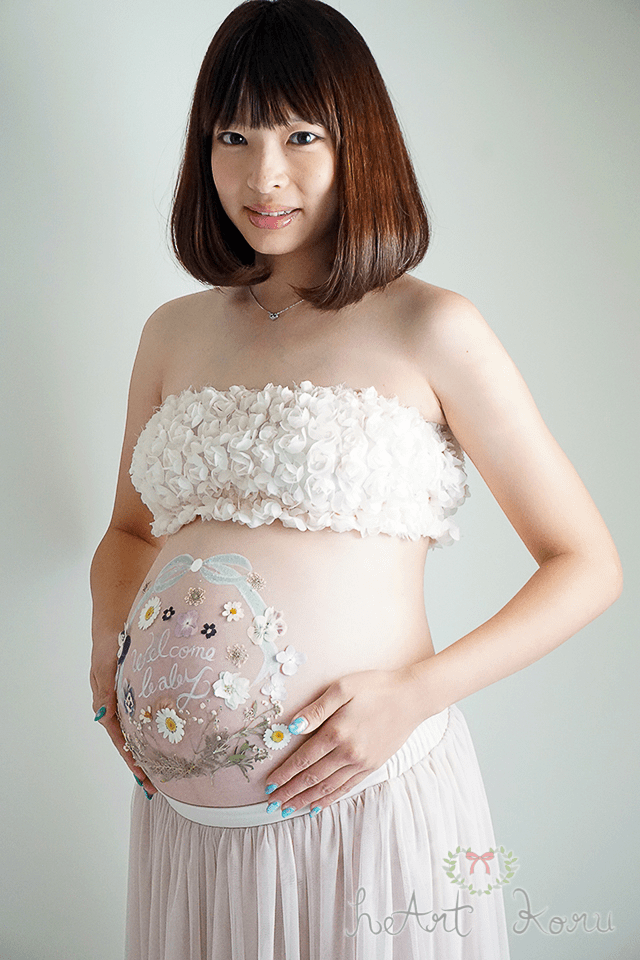 爽やかなベリーペイント のデザイン。お腹には本物の押し花を使ってマタニティペイントをしている。妊婦さんが嬉しそうな表情。