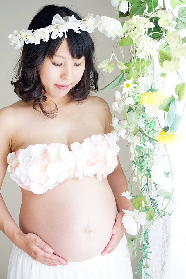 ベリーペイント（マタニティペイント）前のマタニティフォト。看護師の妊婦さん。2人目を妊娠中。お腹の赤ちゃんを見つめている。自然光で撮影した美しいマタニティ写真。