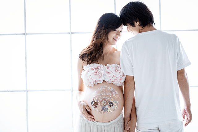 押し花を使った3D マタニティペイント（ベリーペイント）の可愛いマタニティアート。パパとママで一緒に撮影した、おしゃれなマタニティフォト。自然光が美しいマタニティ写真。2人目妊娠中。